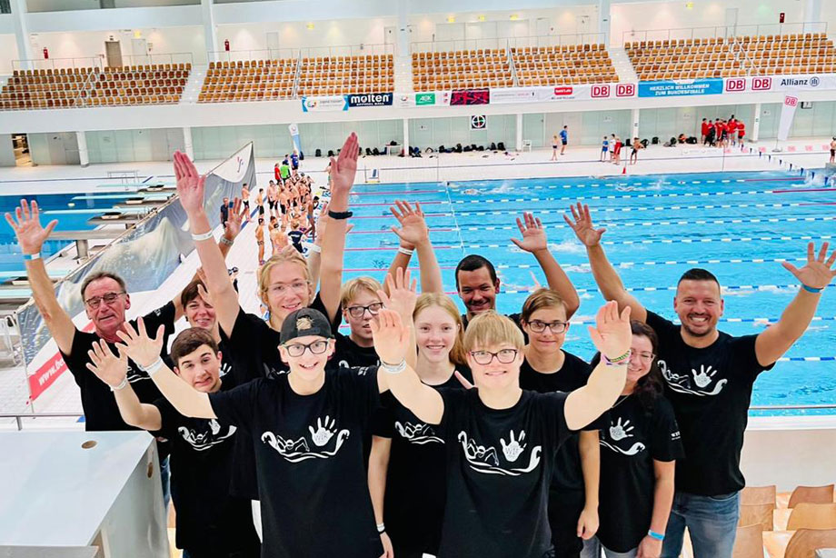 Jubelndes CHS-Schwimmteam vor Schwimmbecken