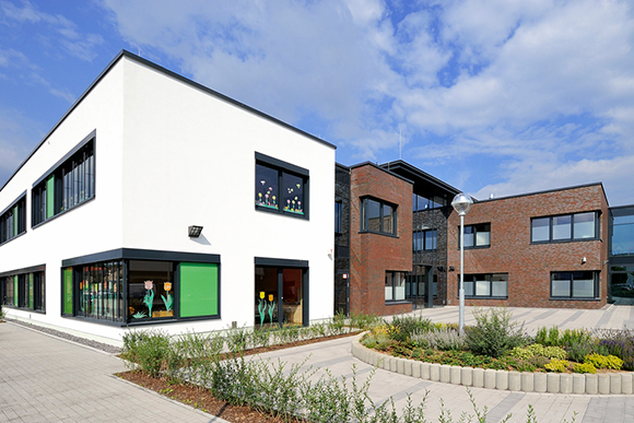 Moderner Neubau der CHS mit Grünflächen im Vordergrund.